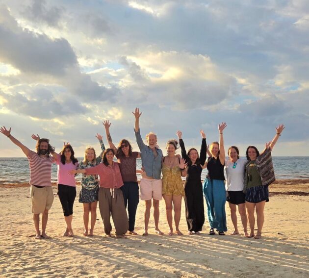300-hour yoga teacher training group celebrating on the beach in Puerto Morelos, Mexico