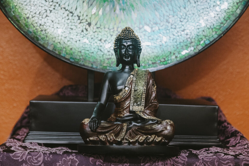 Seated Buddha before a mosaic mirror at Karma Yoga Center