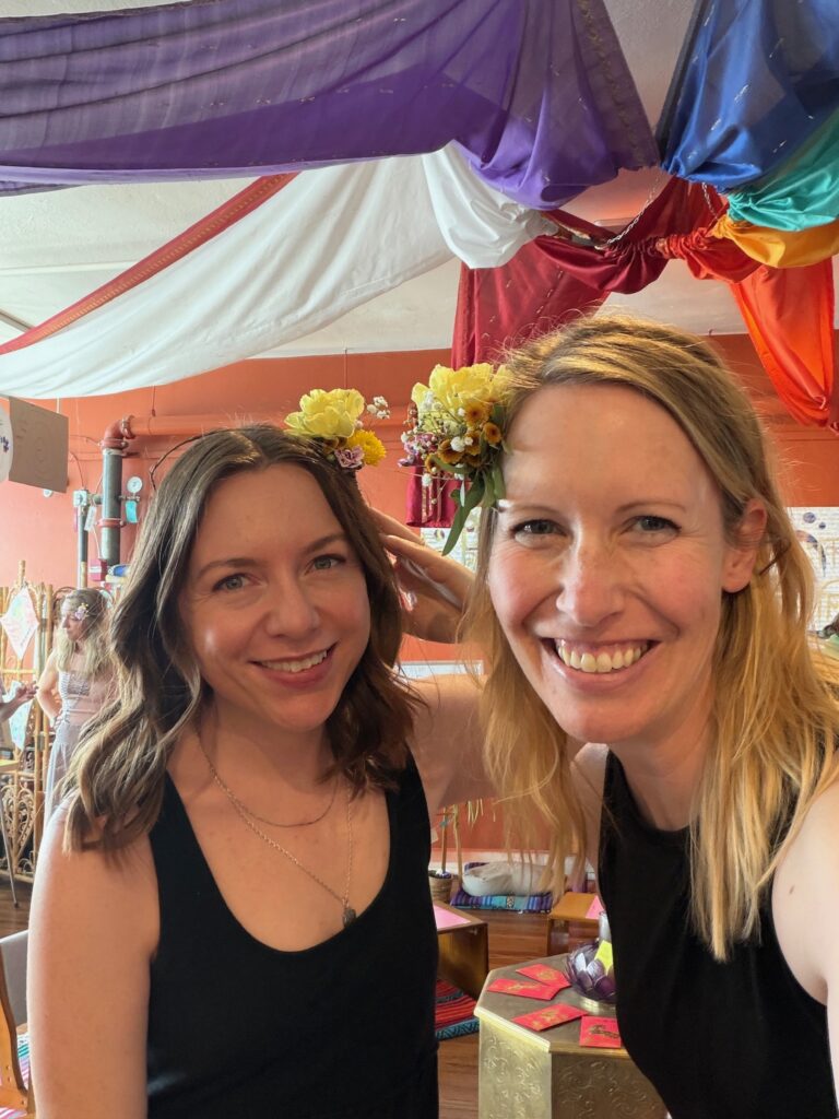 Friends with flower crowns at a seasonal celebration at Karma Yoga Center