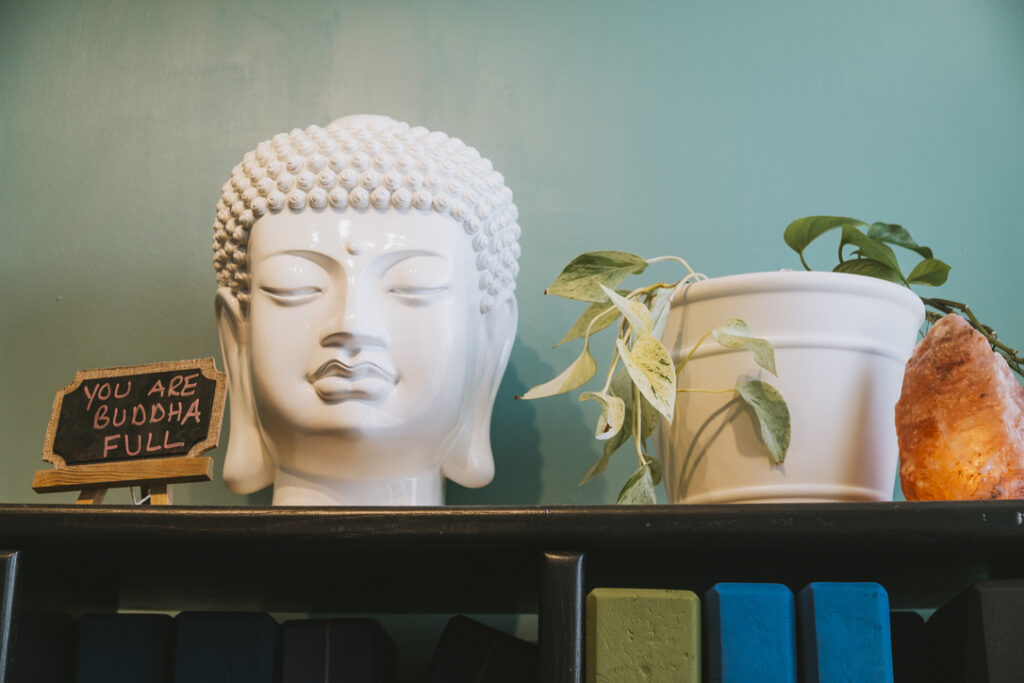 White Buddha head with "You Are Buddha Full" sign at Karma Yoga Center