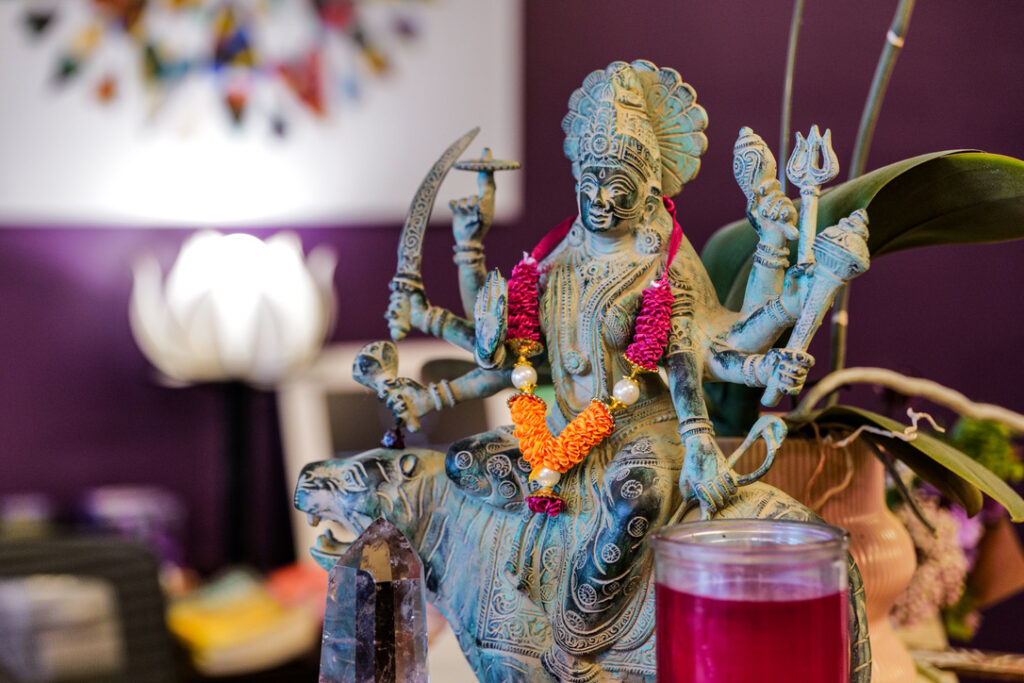 Durga statue with garland and crystal at Karma Yoga Center