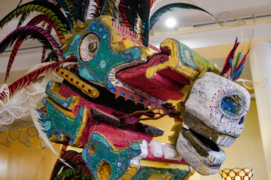 Feathered serpent sculpture hanging in the community space at Karma Yoga Center