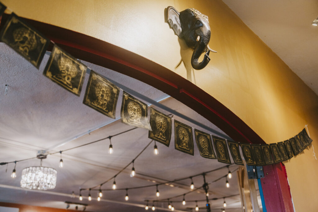 Elephant head and prayer flags over the main studio archway at Karma Yoga Center