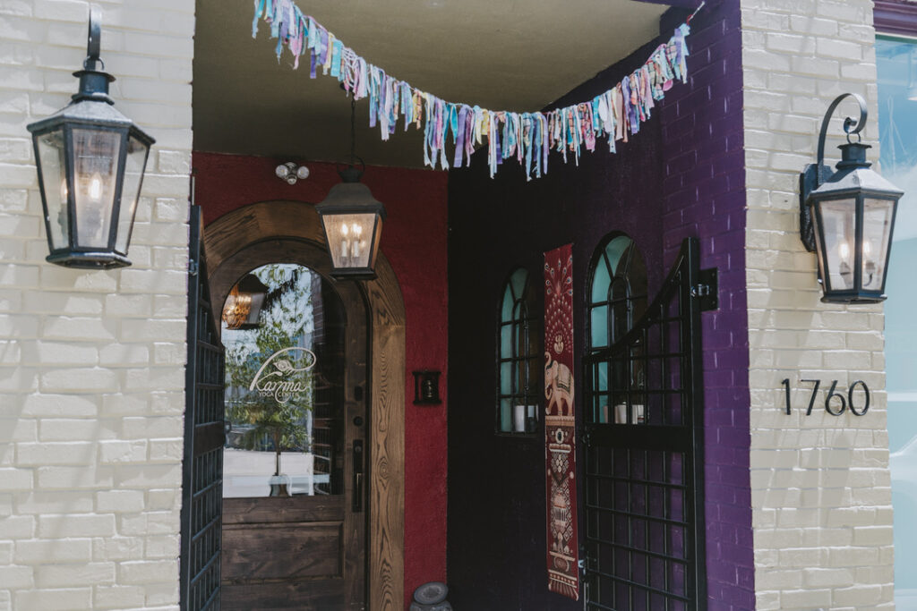 Arched wooden front door with lanterns at Karma Yoga Center, 1760 S. Broadway