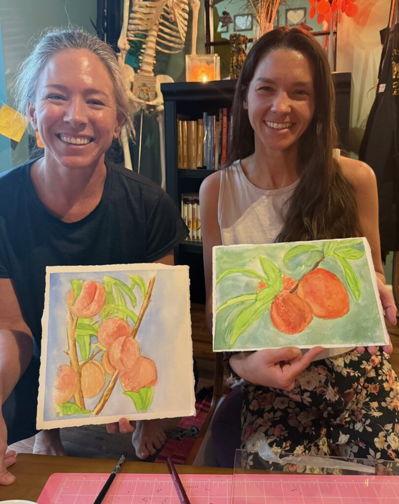 Students sharing watercolor paintings from a heArt & Soul class at Karma Yoga Center