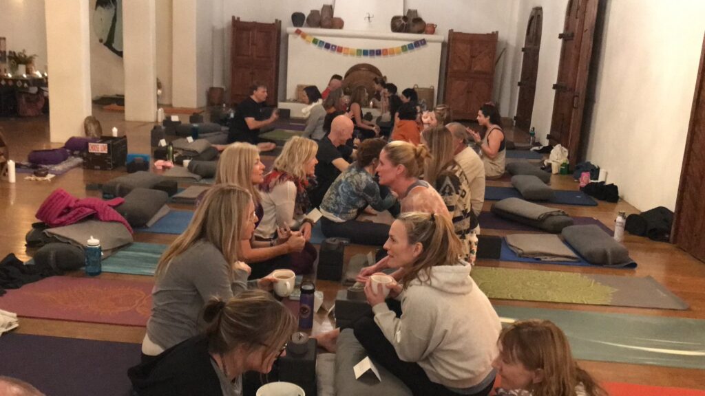 Retreat participants on mats in a hacienda hall in New Mexico