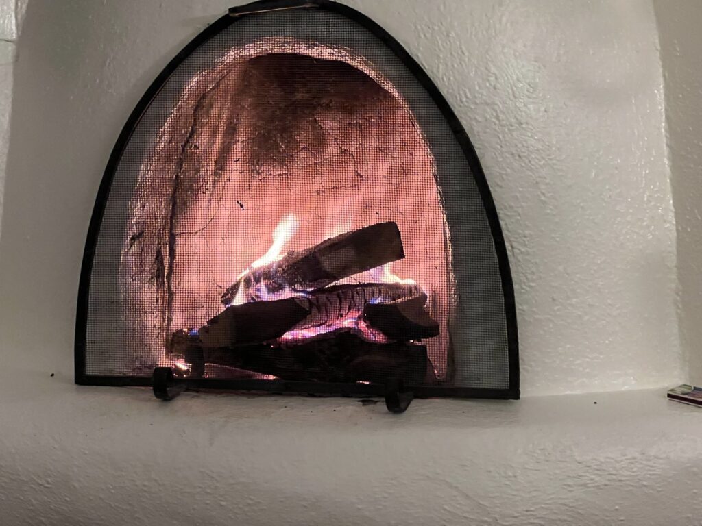Kiva fireplace glowing at the New Mexico retreat