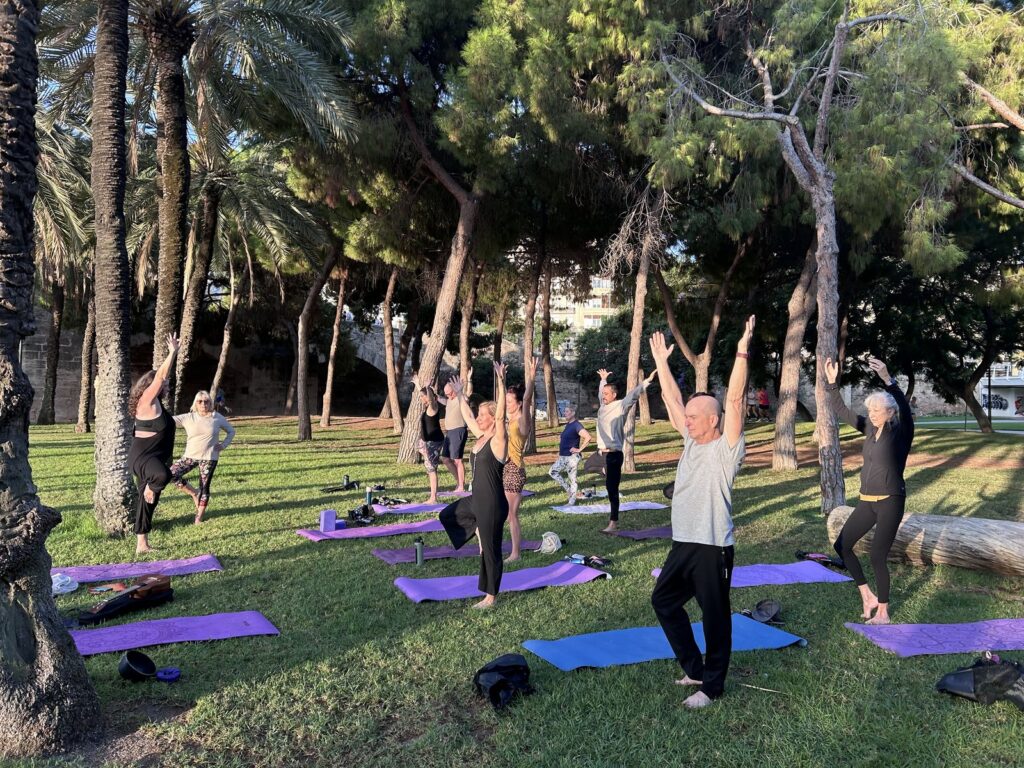 Outdoor yoga class in a park during the Spain retreat