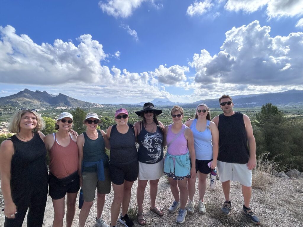 Sacred Spain 2026 group cheering on a mountain hike near El Botánico, Sagra
