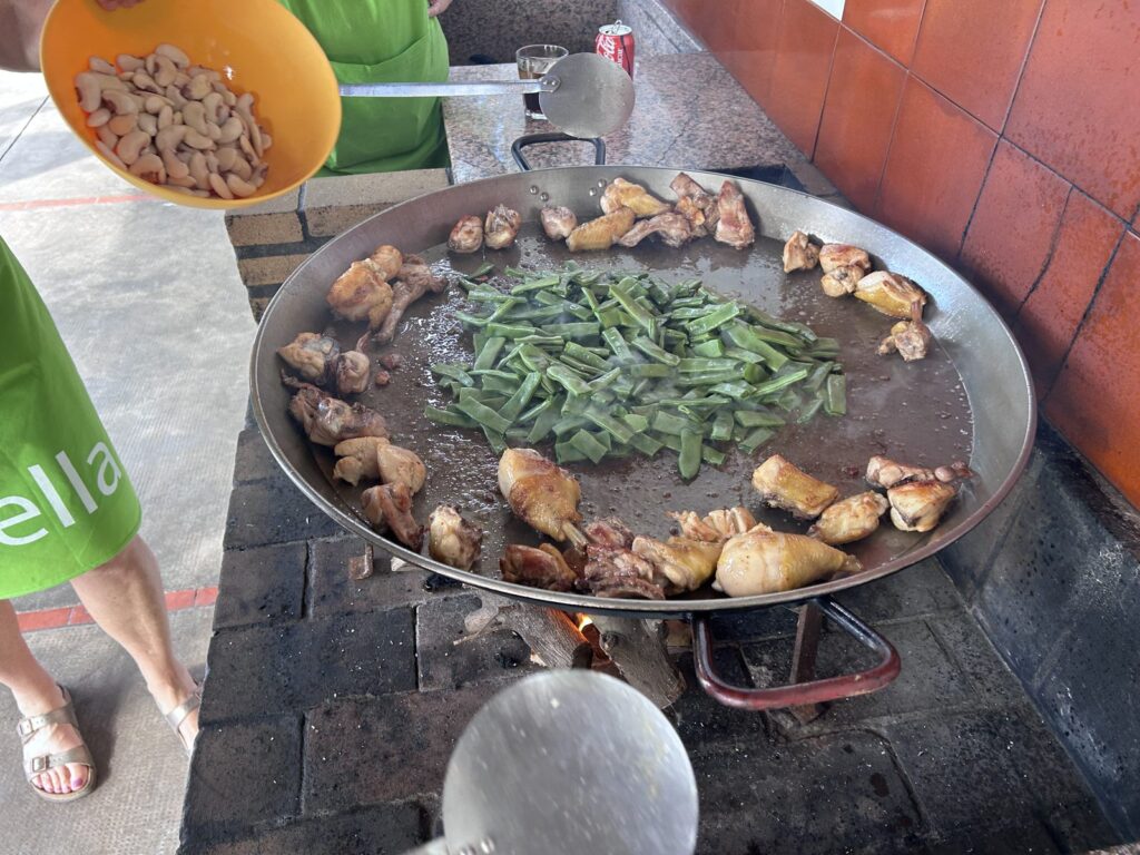 Traditional Valencian paella cooking over an open fire