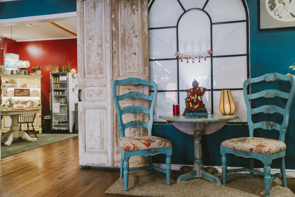 Café nook with blue chairs beside the community kitchen at Karma Yoga Center