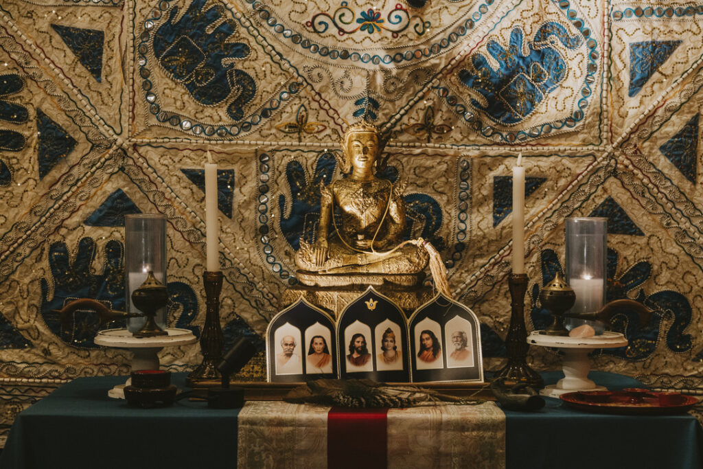 Golden Buddha and guru altar in the meditation room at Karma Yoga Center