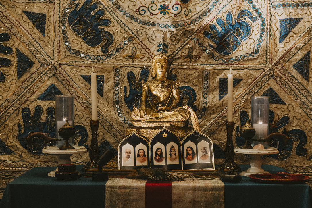 Golden Buddha and guru altar in the meditation room at Karma Yoga Center