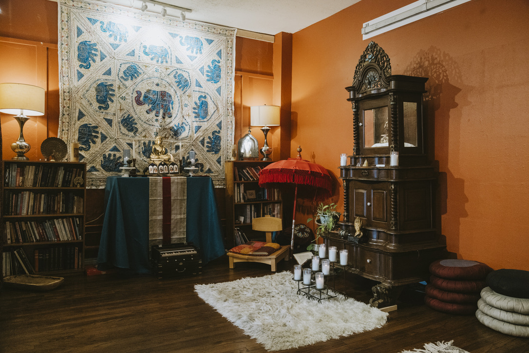 Meditation room library, altar, and shrine cabinet at Karma Yoga Center