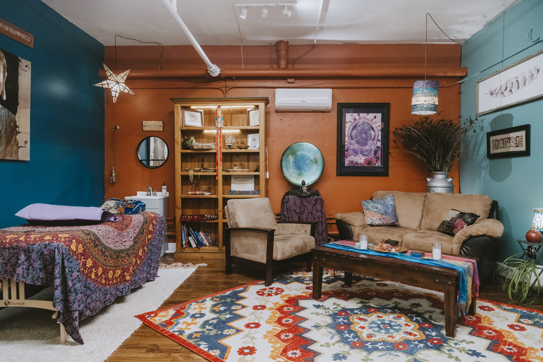 Healing table, couch and colorful rug in The Shaman & The Mermaid room