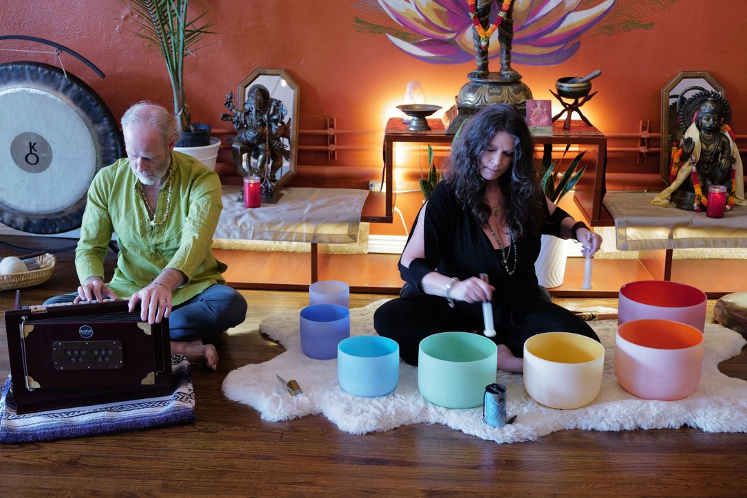 Katrina Gustafson playing crystal singing bowls during a sound healing at Karma Yoga Center, Denver