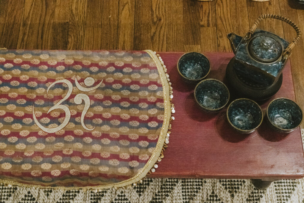 Tea ceremony set on an Om runner at Karma Yoga Center