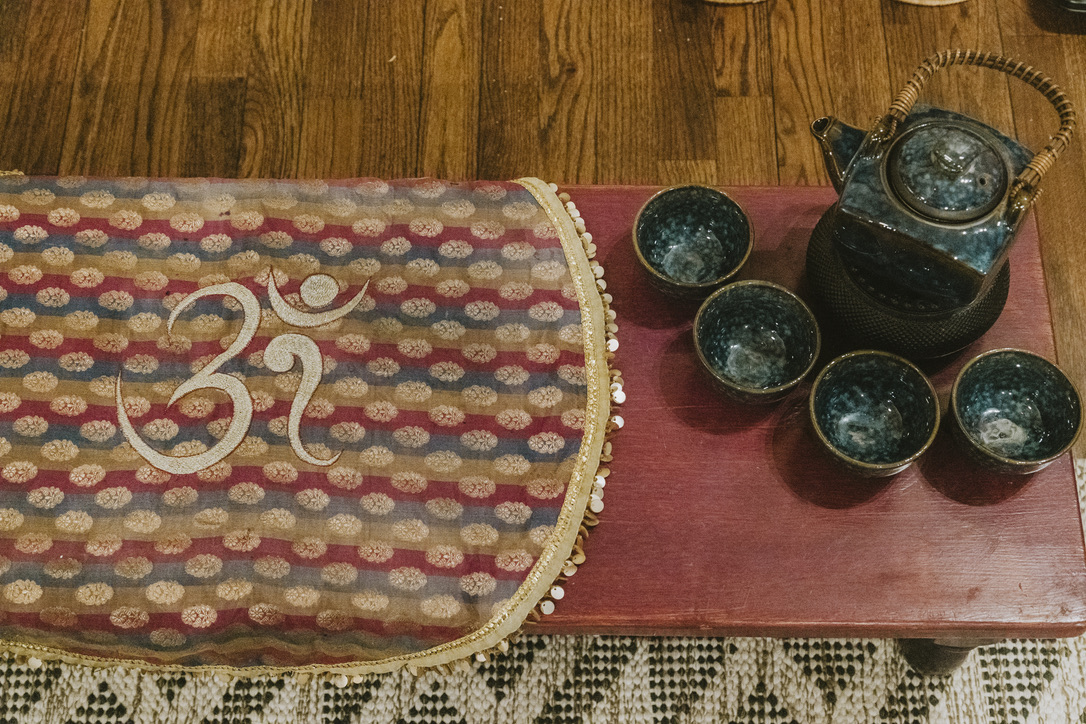 Tea ceremony set on an Om runner at Karma Yoga Center