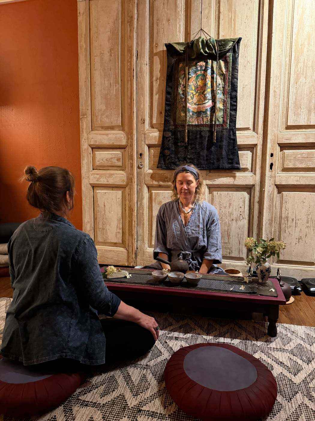 A guest seated for tea ceremony in the Tea Room at Karma Yoga Center