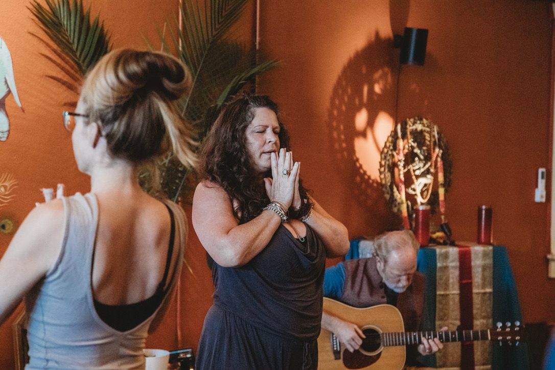 Yoga class with live guitar music in the main studio at Karma Yoga Center