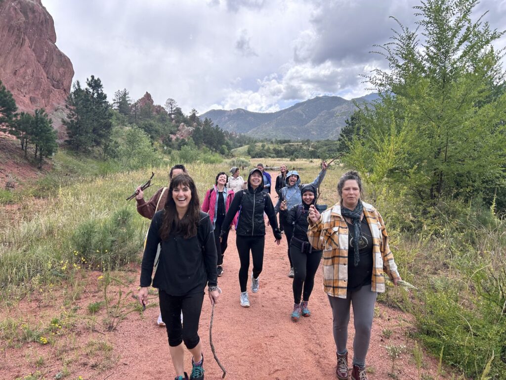 Yoga teacher trainees hiking among the red rocks during the Manitou Springs mountain retreat