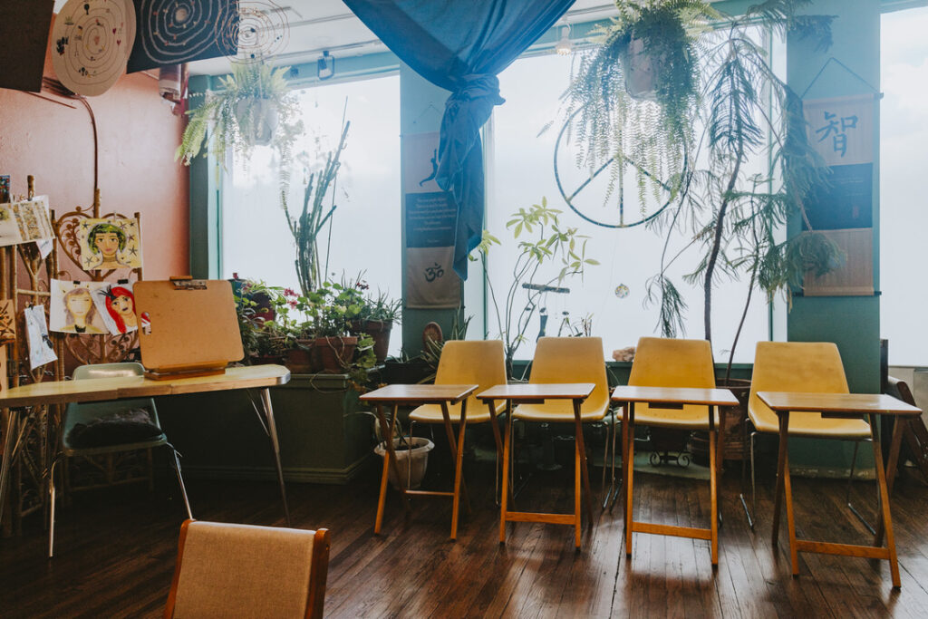 Window desks and plants in the teacher training and art room at Karma Yoga Center